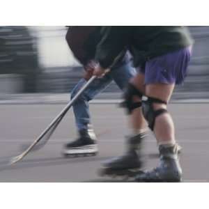  Two Men Battle for the Puck During a Roller Hockey Game 